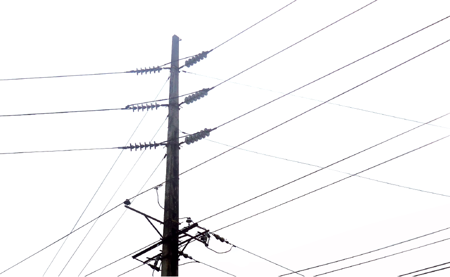 Poste de electricidad urbana muy cargados mostrando muchos cables